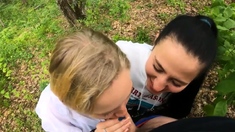 Two Girlfriends Suck Cock in the Wood