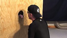 Gay hunk sucks on a stranger's rock-hard jackhammer through a glory hole